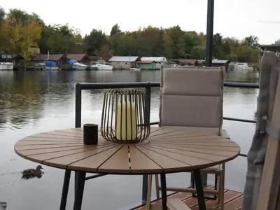 a wooden table and a chair and a cup on a table at Houseboat Rosie in Prague