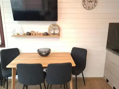 a dining room with a wooden table and four chairs at Houseboat Rosie in Prague