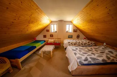 a attic bedroom with two beds and a table at Ubytování Hrusice in Hrusice