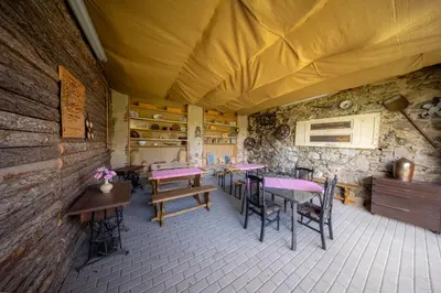 a room with tables and chairs and a stone wall at Ubytování Hrusice in Hrusice