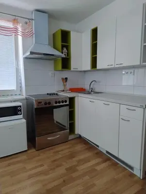 a kitchen with white cabinets and a stove top oven at Apartmán Sofie in Poděbrady