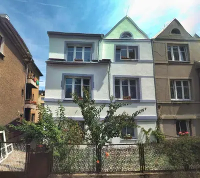 a white house with a fence in front of it at Apartmán Sofie in Poděbrady