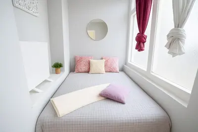 a window seat in a room with pink pillows at Just Steps from Wenceslas Square! in Prague