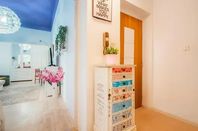 a room with a dresser with flowers in it at Just Steps from Wenceslas Square! in Prague