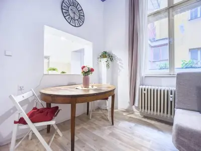 a small room with a table and a clock on the wall at Just Steps from Wenceslas Square! in Prague