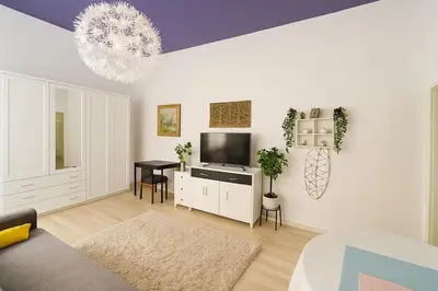 a white living room with a television and a table at Just Steps from Wenceslas Square! in Prague