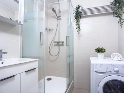 a bathroom with a shower and a washing machine at Just Steps from Wenceslas Square! in Prague