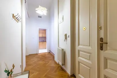 a hallway with a white door and a wooden floor at Designový Apartmán in Prague