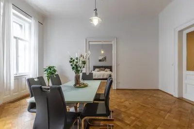 a dining room with a green table and black chairs at Designový Apartmán in Prague