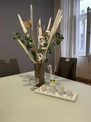 a white table with a vase with white flowers and candles at Designový Apartmán in Prague