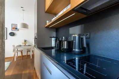 a kitchen with a black counter top and a table at Stylish Apartment in Prague's Historic Centre in Prague