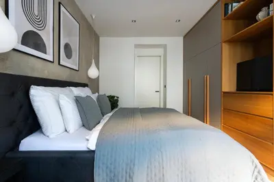 a bedroom with a bed with white pillows and a tv at Stylish Apartment in Prague's Historic Centre in Prague
