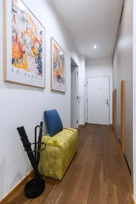 a living room with a yellow chair and a white wall at Stylish Apartment in Prague's Historic Centre in Prague