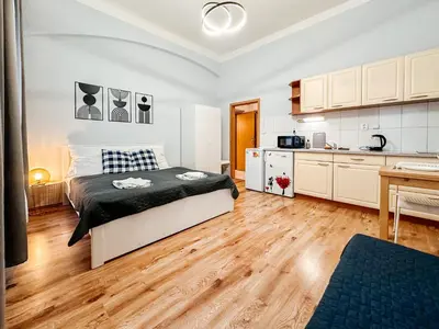 a bedroom with a bed and a kitchen at MIVA apartments in Prague