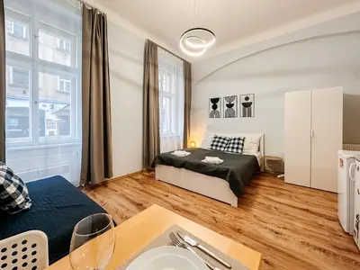 a bedroom with a bed and a table at MIVA apartments in Prague
