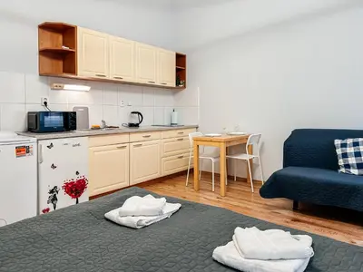 a small kitchen with a blue couch and a table at MIVA apartments in Prague