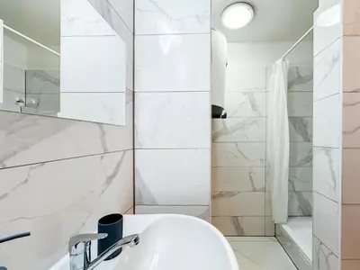a white bathroom with a sink and a shower at MIVA apartments in Prague