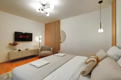 a bedroom with a white bed and a chair at CityMood Prague Apartment in Prague