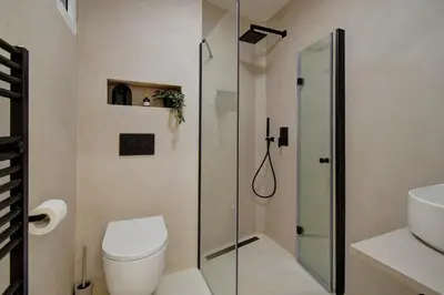 a bathroom with a toilet and a glass shower at CityMood Prague Apartment in Prague