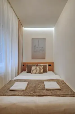 a bedroom with a large bed with two towels on it at CityMood Prague Apartment in Prague