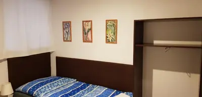 a bedroom with a bed and three pictures on the wall at Pension & Restaurace Na Rychtě in Prague