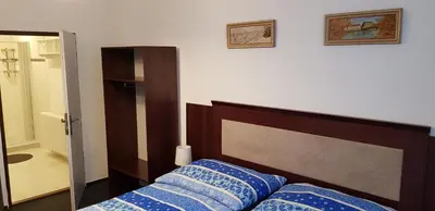 a bedroom with a bed with blue pillows on it at Pension & Restaurace Na Rychtě in Prague