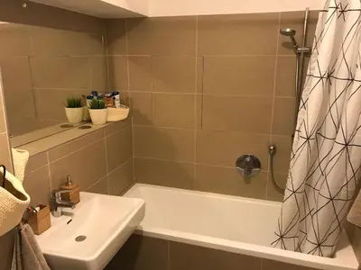 a bathroom with a bath tub and a sink at COSY&SUNNY flat, center 10min, park 3min, baby cot, free weekend parking in Prague