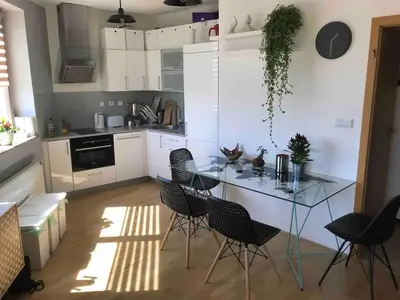 a kitchen with a glass table and chairs at COSY&SUNNY flat, center 10min, park 3min, baby cot, free weekend parking in Prague