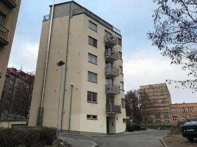 a tall white building with balconies on a street at COSY&SUNNY flat, center 10min, park 3min, baby cot, free weekend parking in Prague