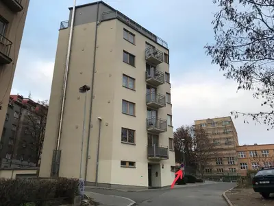 a person is standing in front of a tall building at COSY&SUNNY flat, center 10min, park 3min, baby cot, free weekend parking in Prague