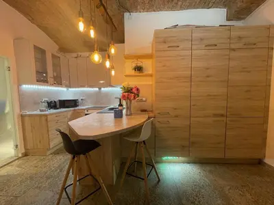 a kitchen with a table and a large wooden cabinet at Urban Zen Apartment in Prague