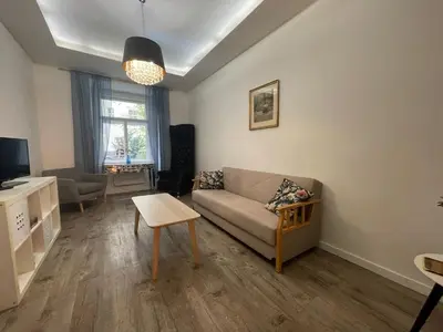 a living room with a couch and a tv at Urban Zen Apartment in Prague