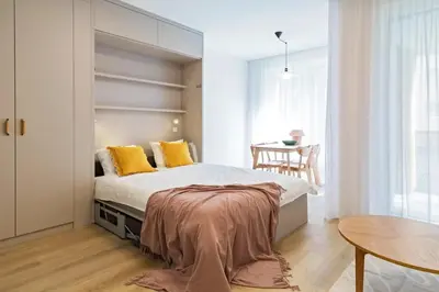 a bedroom with a bed with yellow pillows and a table at ANIMA Home, free parking in Prague