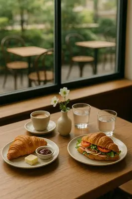 a table with two plates of sandwiches and croissants at ANIMA Home, free parking in Prague