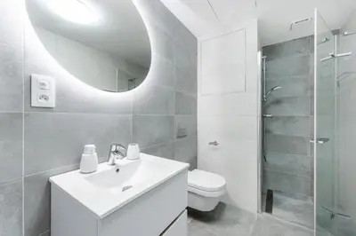 a bathroom with a sink and a toilet and a mirror at Rentero Warm & Cozy Stay in Prague, By the River in Prague