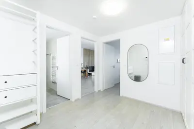 a white room with a mirror and a dresser at Rentero Warm & Cozy Stay in Prague, By the River in Prague