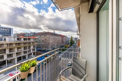 a balcony with a chair and a view of a city at Rentero Warm & Cozy Stay in Prague, By the River in Prague