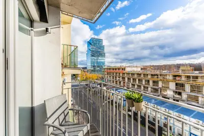 a balcony with a bench and a building at Rentero Warm & Cozy Stay in Prague, By the River in Prague