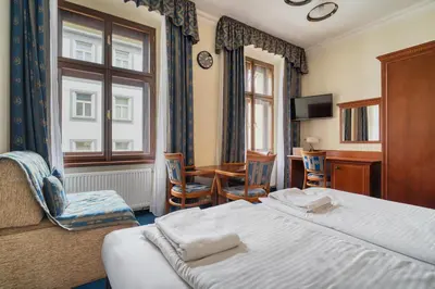a hotel room with a bed and a table and chairs at Cozy Historic City Centre Studio by Rentez in Prague