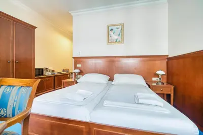 a bedroom with a large bed with a wooden headboard at Cozy Historic City Centre Studio by Rentez in Prague