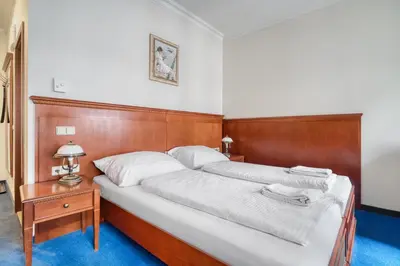 a bedroom with a large bed with a wooden headboard at Cozy Historic City Centre Studio by Rentez in Prague