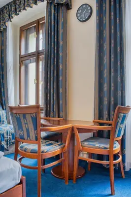 a dining room table with two chairs and a clock at Cozy Historic City Centre Studio by Rentez in Prague