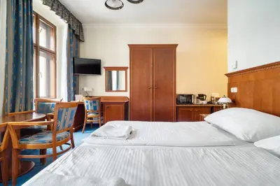 a hotel room with a bed and a table and chairs at Cozy Historic City Centre Studio by Rentez in Prague