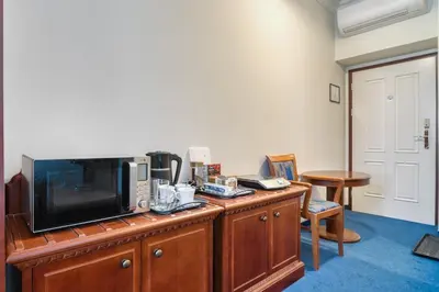 a room with a tv on a wooden dresser at Cozy Historic City Centre Studio by Rentez in Prague