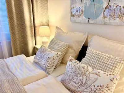 a room with a bed with pillows and a lamp at My Sweet Home - Zakšínská - Prague in Prague