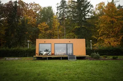 a tiny house sitting on top of a lush green field at ermiglamping in Jince