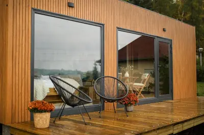 a house with two chairs on a wooden deck at ermiglamping in Jince