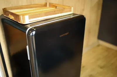 a black refrigerator with a wooden box on top of it at ermiglamping in Jince