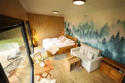 a bedroom with a bed and a couch and a table at ermiglamping in Jince