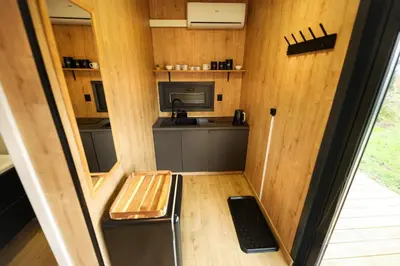 a small kitchen in a tiny house with a bench at ermiglamping in Jince